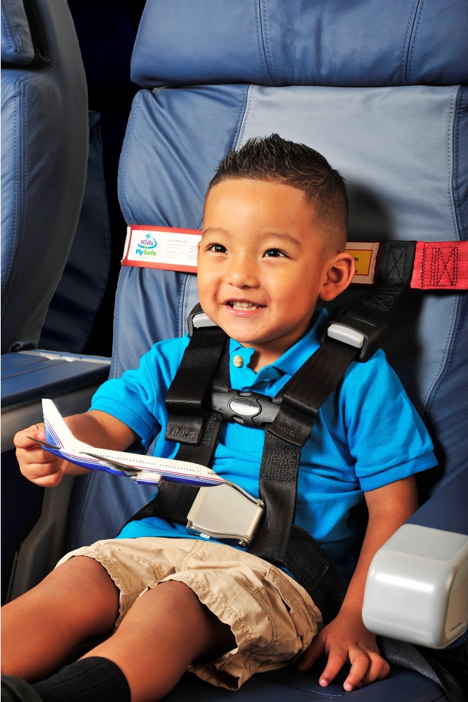 Kleinkind im Flugzeug mit Sicherheitsgurt Cares